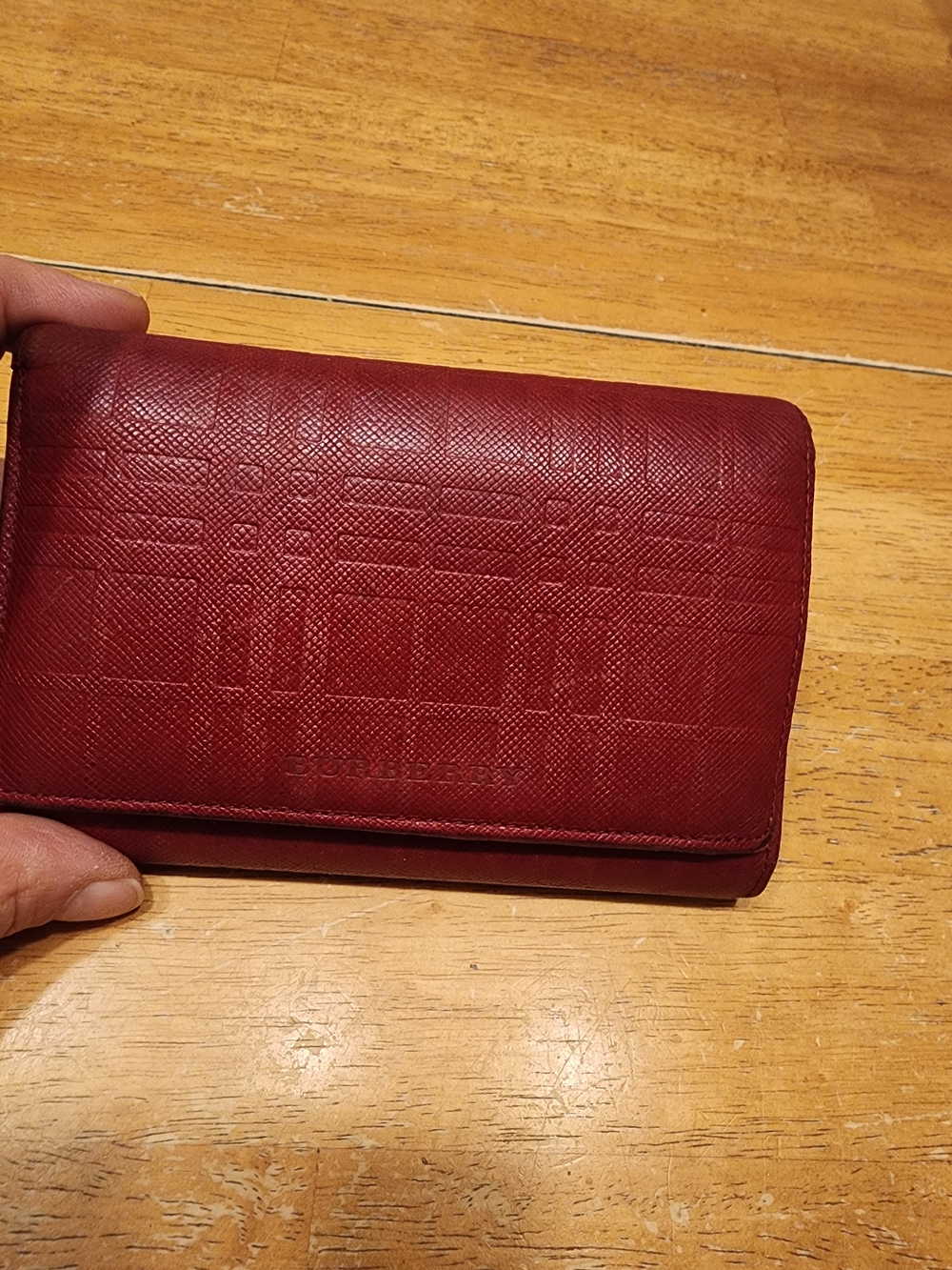 red embossed check leather wallet by Burberry featuring a textured finish